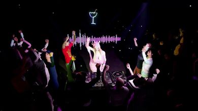 A naked DJ spinning records and teasing the crowd with her sexual moves, causing the audience to become extremely aroused.